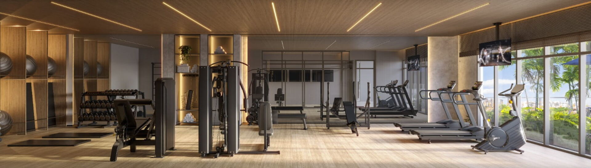 Academia equipada com esteiras, aparelhos de musculação e vista para o verde