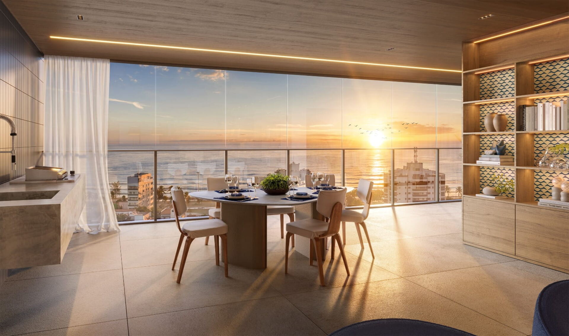Varanda gourmet com mesa posta ao pôr do sol, vista para o mar da Barra da Tijuca